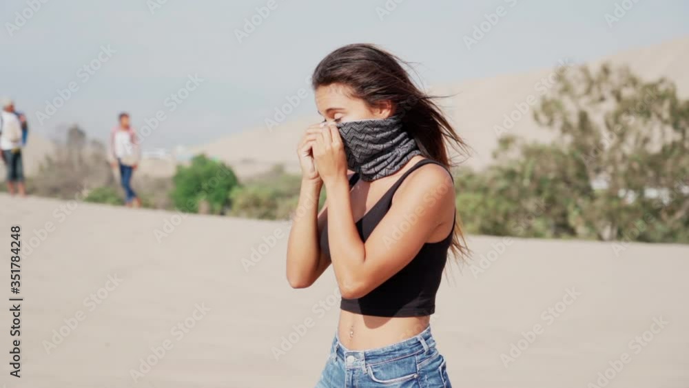 Slow motion shot of young woman wearing scarf while walking at desert during sunny day - Huacachina, Peru Slow motion shot of young woman wearing scarf while walking at desert during sunny day - Huacachina, Peru