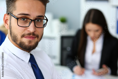 Handsome smiling bearded clerk man wearing glasses