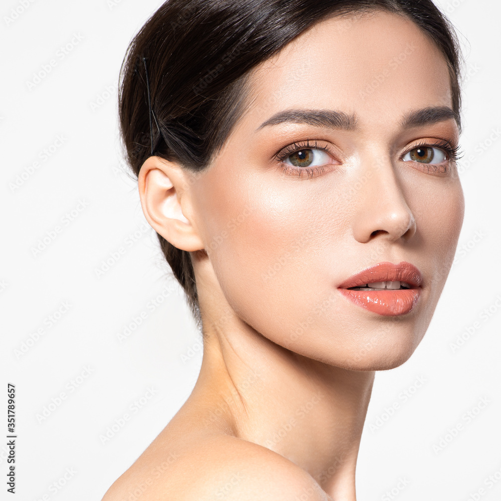 Obraz premium Beautiful face of young woman with health fresh skin. Portrait of beautiful brunette woman with clean face. Beautiful face of young adult woman with clean fresh skin - isolated on white. Skin care.