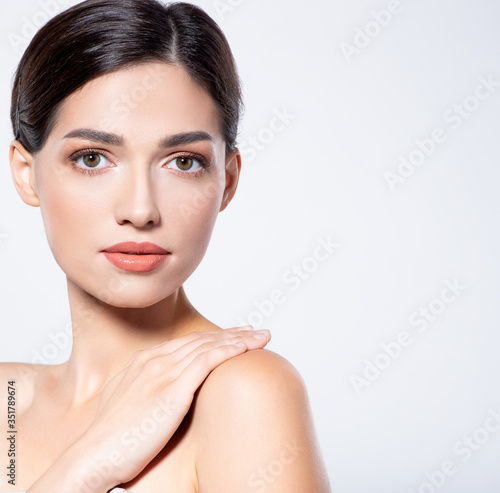 Portrait of beautiful brunette woman with clean skin of face - isolated on white. Photo of an Young girl with light natural eye makeup. Beauty face of young woman with healthy fresh skin.