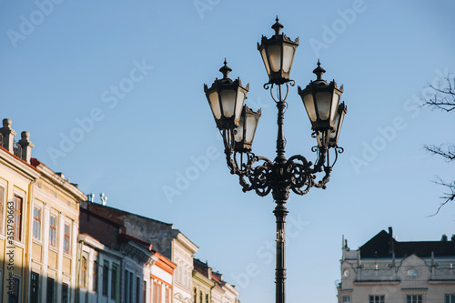 An old vintage lantern in the historical center of Lviv on blue sky background. The concept of spring city. © shchus