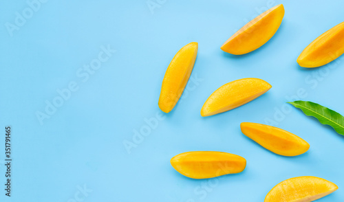 Tropical fruit, Mango  slices with leaf on blue background.