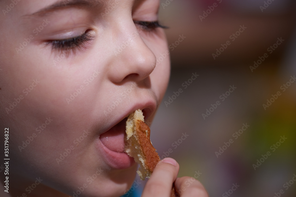 boy, child eats a bun inhales the pleasant aroma of fresh pastries. boy, child eats a bun inhales the pleasant aroma of fresh pastries.