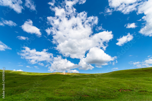 Green hills against the blue sky with clouds. Beautiful screensaver.