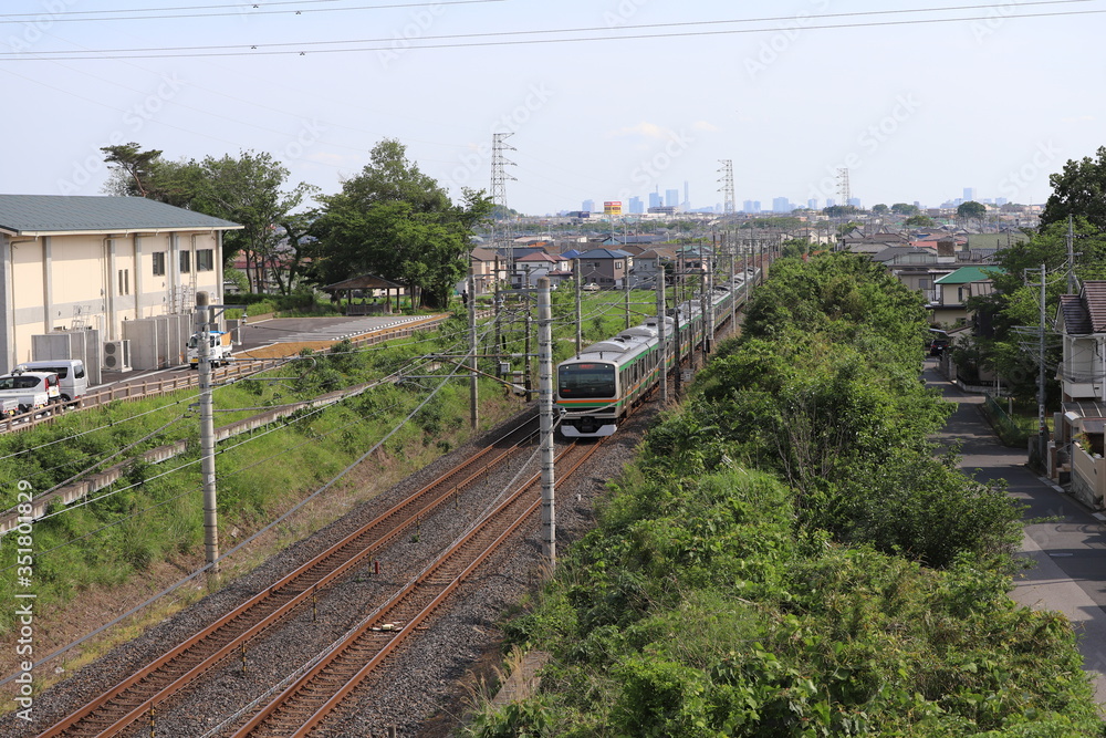 Naklejka premium 埼玉県蓮田駅付近を走行するE231系通勤電車