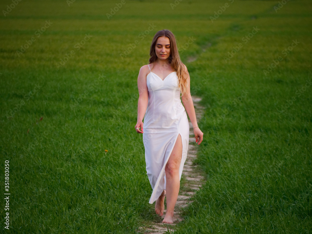 girl in a long white dress on a green field girl in a long white dress on a green field