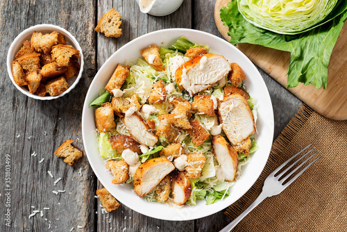 Classic caesar salad with grilled chicken fillet and parmesan cheese. top view