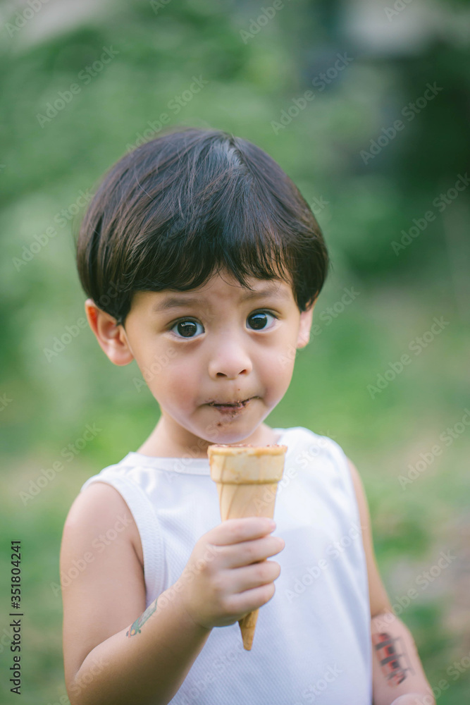 Asia boy he mouth aftertaste from eating chocolate ice cream or chocolate dessert. A sweet-toothed child eat chocolate. Kid with dirty face eating ice cream. Cute toddler boy eating icecream. Asia boy he mouth aftertaste from eating chocolate ice cream or chocolate dessert. A sweet-toothed child eat chocolate. Kid with dirty face eating ice cream. Cute toddler boy eating icecream.