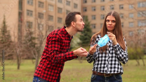 Wallpaper Mural Man in love wants to kiss girl defends against him during pandemic coronavirus by putting on medical mask and keep distance. Virus spread prevention and people concept. Torontodigital.ca