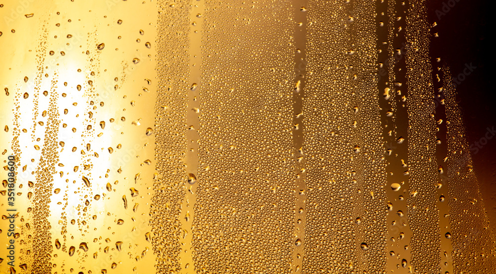 Drops of water on a glass window at dawn as an abstract background.