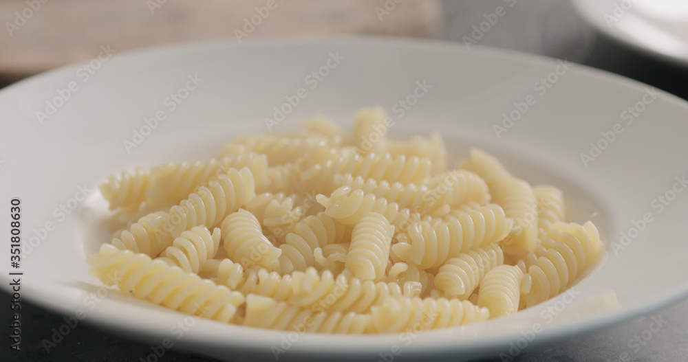 steam rising from boiled hot fusilli in white plate closeup steam rising from boiled hot fusilli in white plate closeup