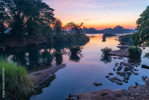 Beautiful landscape view of sunrise and old wooden boat drop nearly the river in front of guest house from Don Det the famous place for tourist to relaxing at Siphondon island, Laos. photo