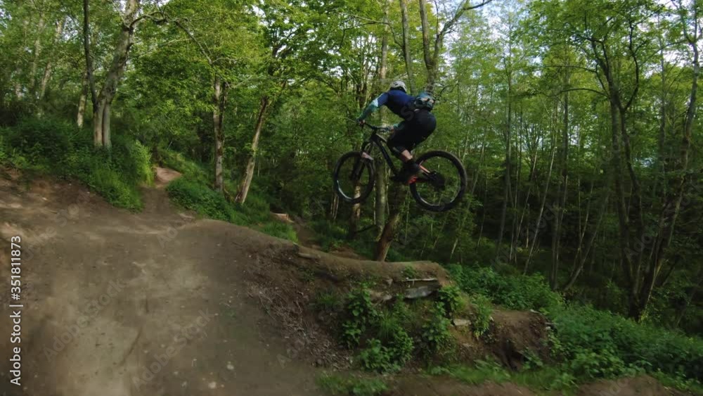 Young Man Whipping Mountain Bike Over Dirt Jump Line Young Man Whipping Mountain Bike Over Dirt Jump Line
