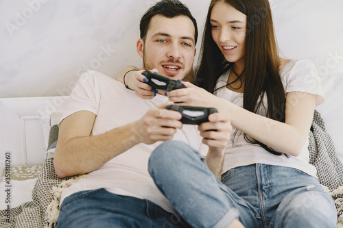 Couple with joysticks. People at home. Pair playing a video games.