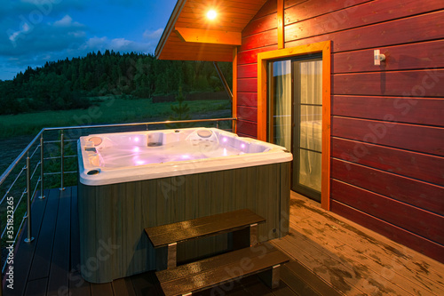 The illuminated hot tub is filled with water. SPA treatments in