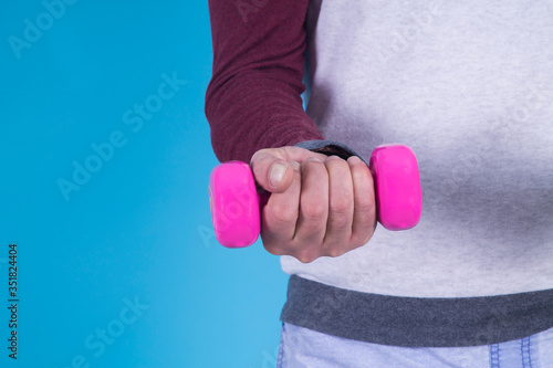 hand holding dumbbell on blue background