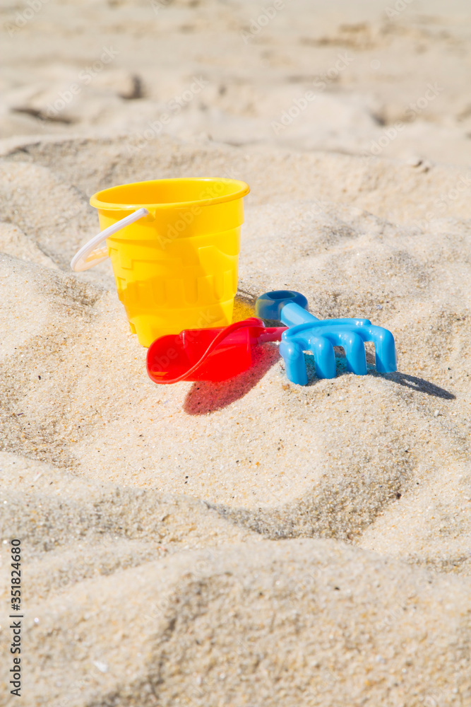 bucket, shovel and rake on beach sand, summer vacation concept bucket, shovel and rake on beach sand, summer vacation concept