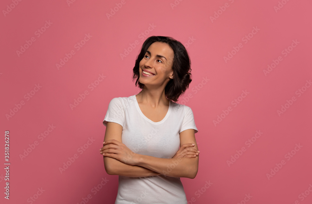 After a good nap. Attractive woman in white t-shirt is looking to the left upper corner, while smiling with folded arms. After a good nap. Attractive woman in white t-shirt is looking to the left upper corner, while smiling with folded arms.