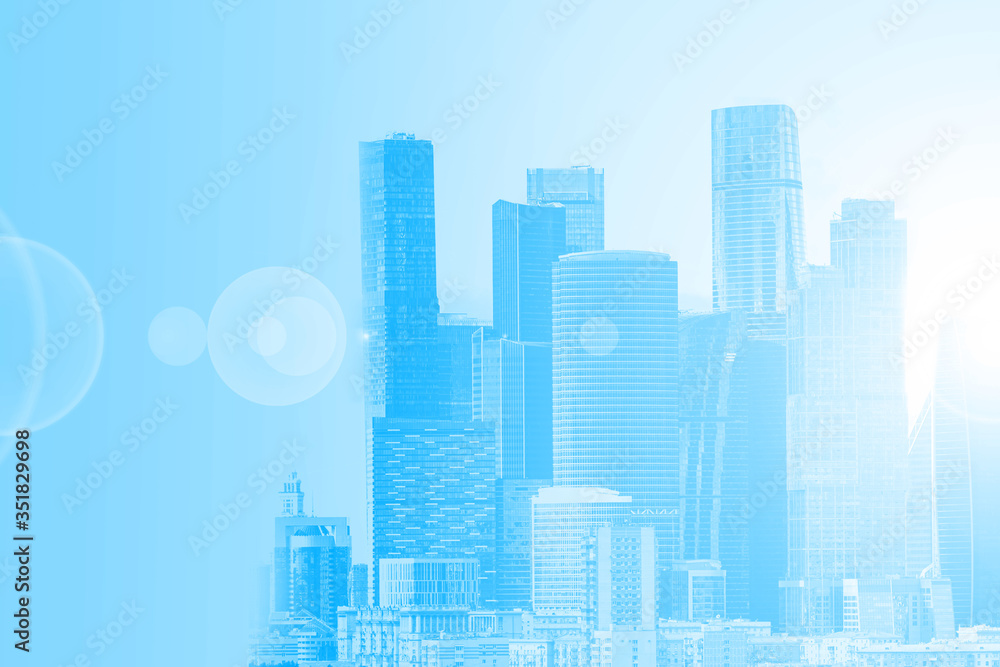 Blue urban background. Skyscrapers in a soft blue color. The concept of a modern city. Space for text. City buildings of different heights.