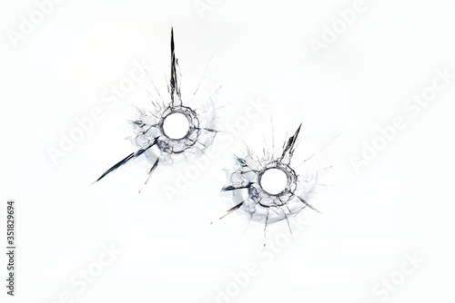 фотографія two bullet hole in glass close up on white background