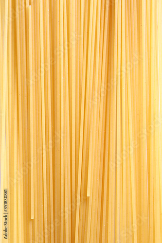 Uncooked Italian spaghetti on a white background.