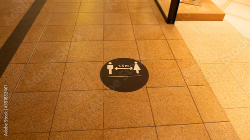 A social distance warning sign on the ground in a shopping mall.The mark was placed because of the coronavirus.