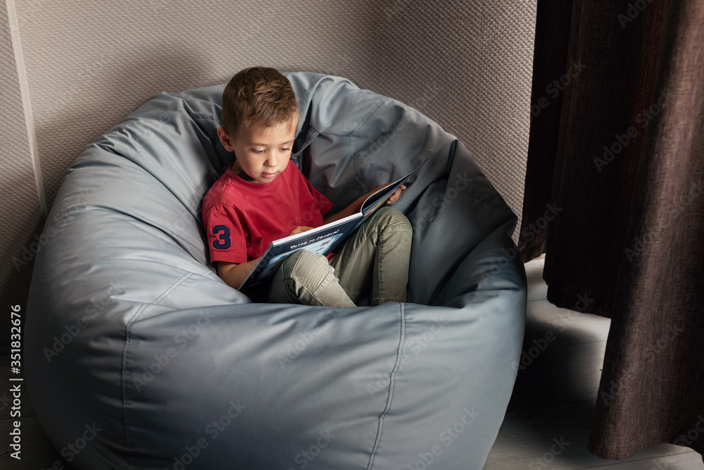 Fototapeta premium Caucasian boy learns to read a book. My first book