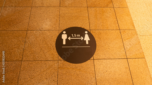 A social distance warning sign on the ground in a shopping mall.The mark was placed because of the coronavirus.