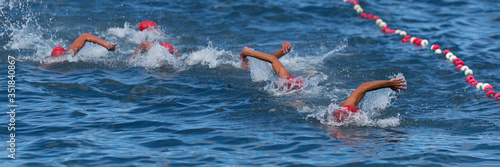 Group of swimmers swim in the sea at the races, open water sport
