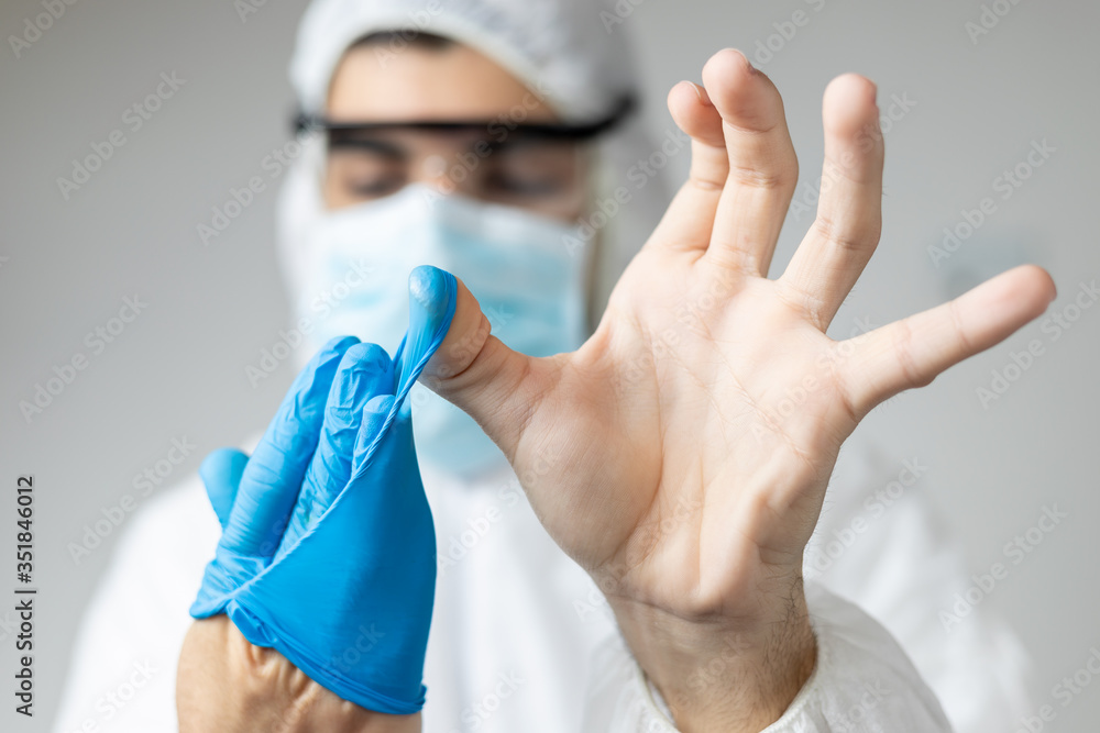 doctor with coronavirus protective clothing showing the correct way to remove the gloves doctor with coronavirus protective clothing showing the correct way to remove the gloves