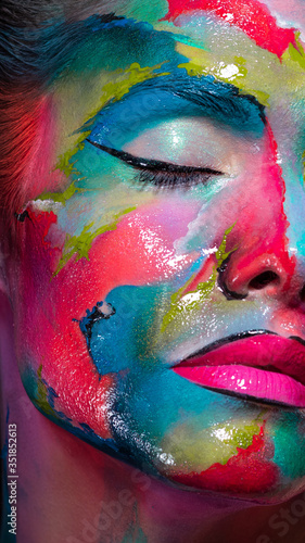 Face art and body art. Creative makeup with colorful patterns on the face. Modern makeup art, bold style,