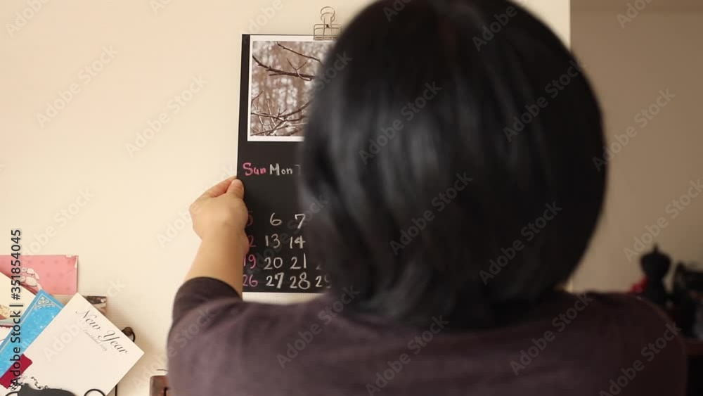 Woman put a calender on the wall. Original design. August. Woman put a calender on the wall. Original design. August.
