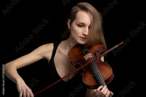 Trendy modern female violinist playing in concert