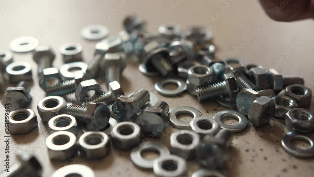 man takes a hand metal mixed bolts, nuts, washers man takes a hand metal mixed bolts, nuts, washers