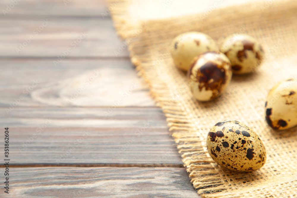 Many quail eggs with sackcloth on brown background Many quail eggs with sackcloth on brown background