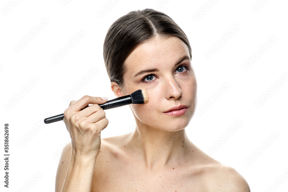 close-up portrait of a girl without makeup with clean skin with a makeup brush in hand, isolated on a white background close-up portrait of a girl without makeup with clean skin with a makeup brush in hand, isolated on a white background