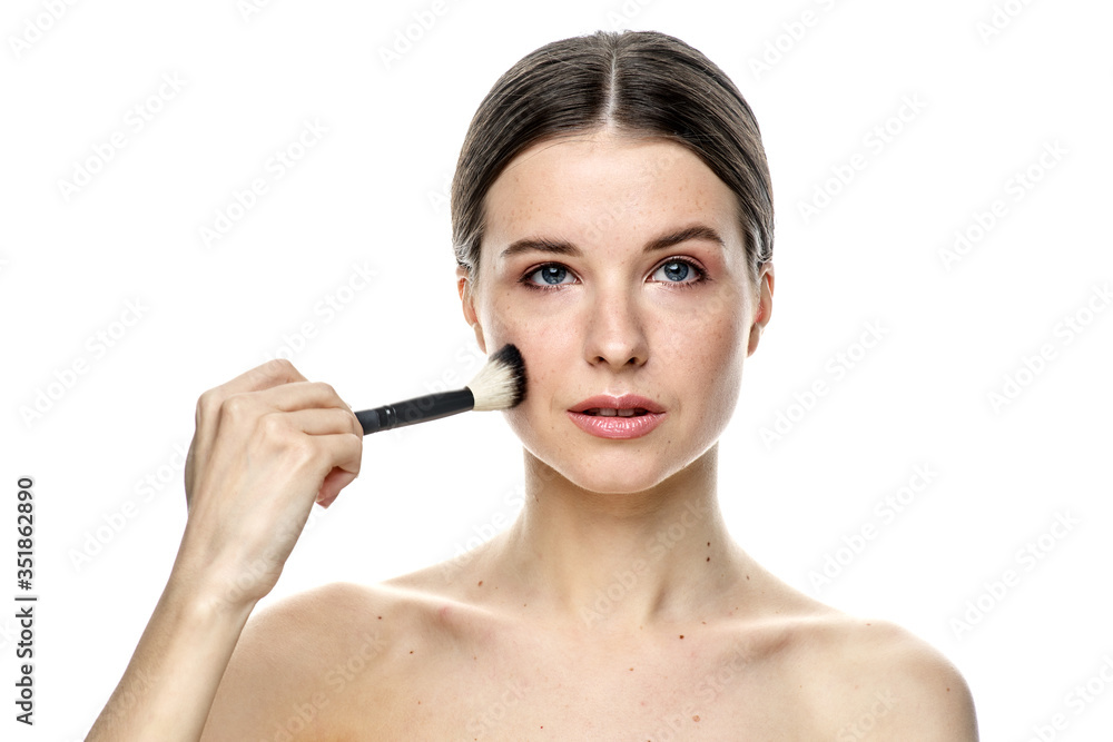 close-up portrait of a girl without makeup with clean skin with a makeup brush in hand, isolated on a white background close-up portrait of a girl without makeup with clean skin with a makeup brush in hand, isolated on a white background