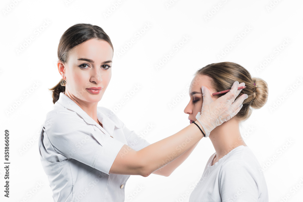 A cosmetologist examines the patient face and plans to perform a series of cosmetic procedures