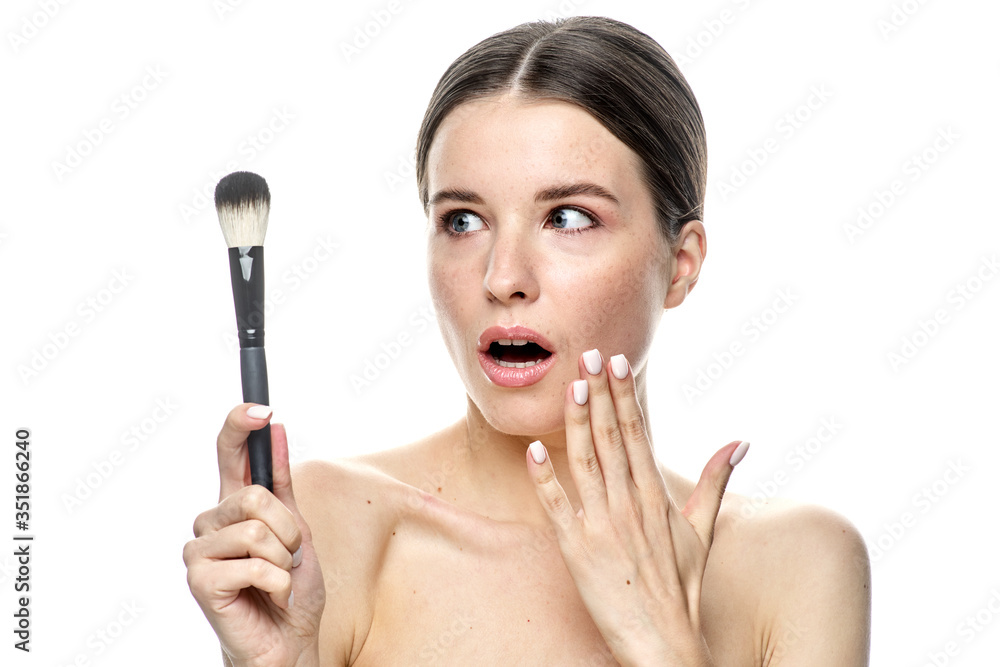 close-up portrait of a girl without makeup with clean skin with a makeup brush in hand, isolated on a white background close-up portrait of a girl without makeup with clean skin with a makeup brush in hand, isolated on a white background