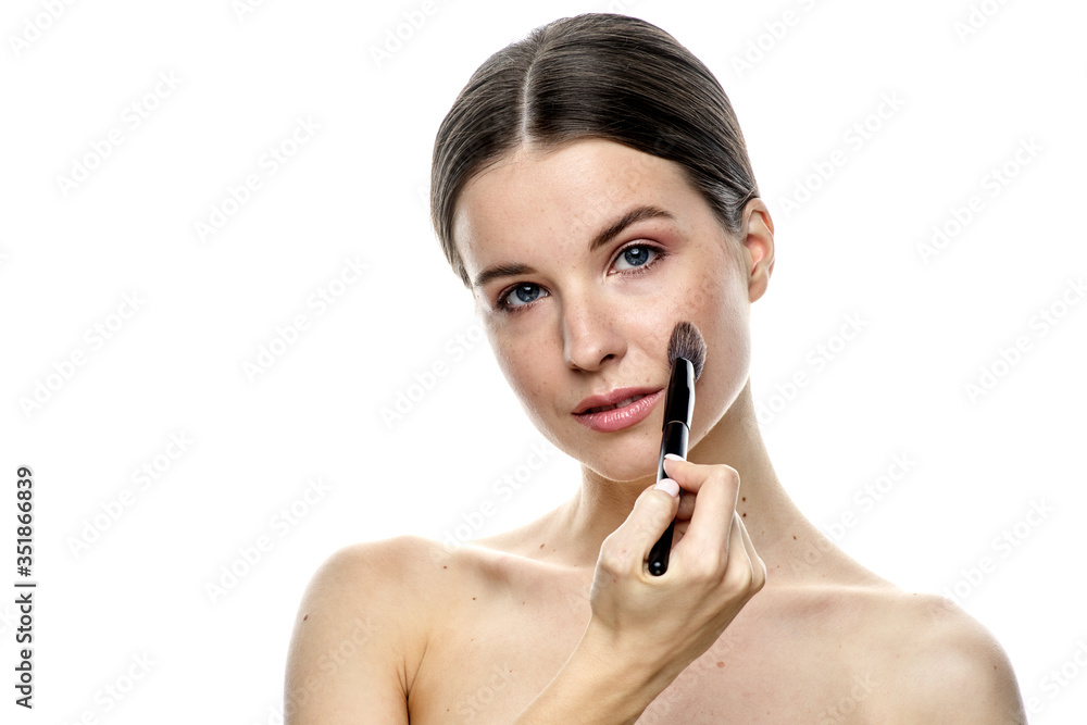 close-up portrait of a young brunette girl with blue eyes with clear skin, doing makeup with makeup brushes, isolated on a white background. High-resolution photos close-up portrait of a young brunette girl with blue eyes with clear skin, doing makeup with makeup brushes, isolated on a white background. High-resolution photos