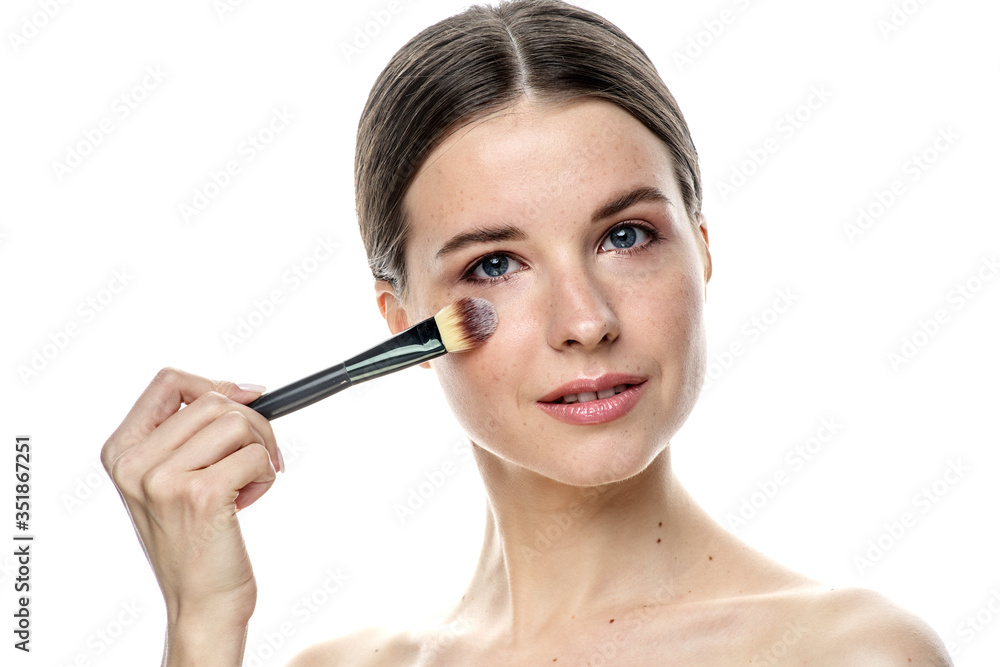 close-up portrait of a young brunette girl with blue eyes with clear skin, doing makeup with makeup brushes, isolated on a white background. High-resolution photos close-up portrait of a young brunette girl with blue eyes with clear skin, doing makeup with makeup brushes, isolated on a white background. High-resolution photos