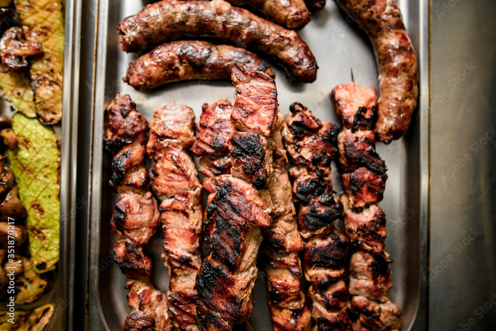 Fototapeta premium Top view on grilled pieces of meat cooked on barbecue.