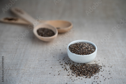 Chia seed in a bowl and on a wooden spoon on the table