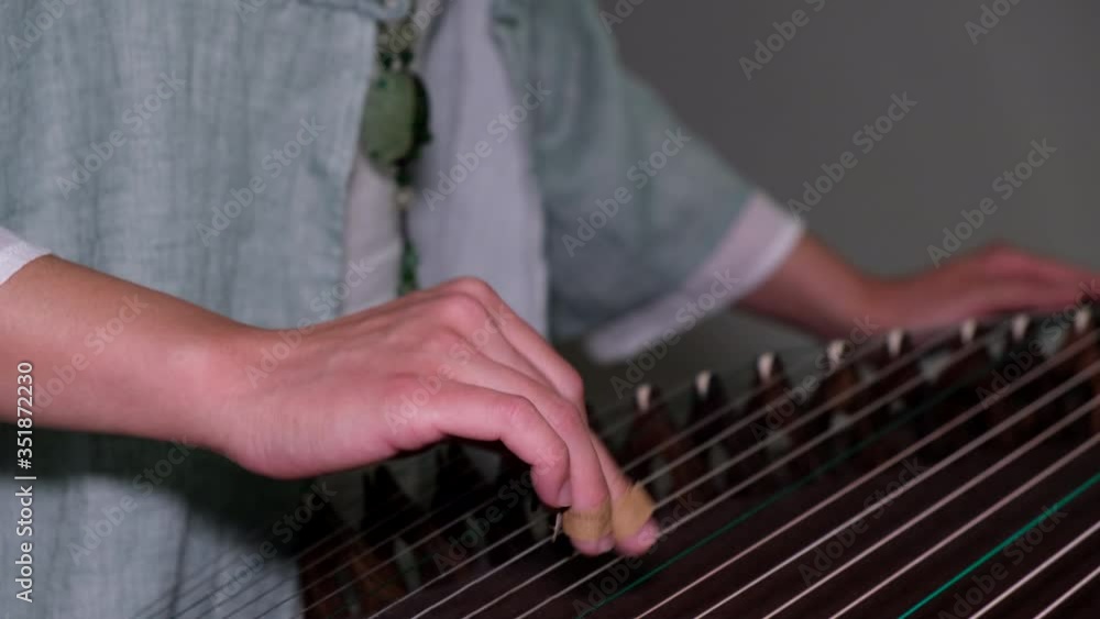Young woman learn Chinese music instrument Guzhen at home amid coronavirus pandemic Young woman learn Chinese music instrument Guzhen at home amid coronavirus pandemic