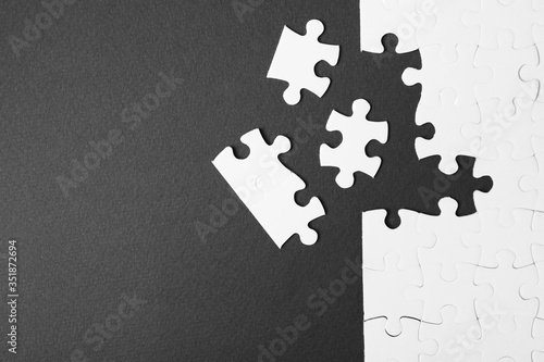 Vászonkép Blank white puzzle with separated pieces on black background, flat lay