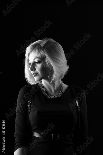 Black and white portrait of a blonde in the studio on a black background