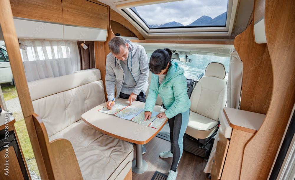 Obraz premium Couples in RV Camper looking at the local map for the trip.
