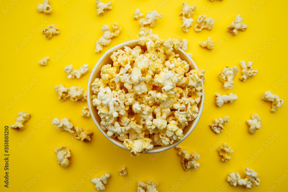 Bowl with popcorn on yellow background. Top view. Entetainement concept. Bowl with popcorn on yellow background. Top view. Entetainement concept.