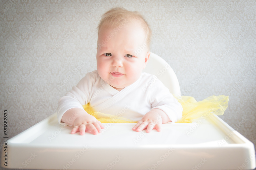 Beautiful little baby in a yellow dress is played with toys Beautiful little baby in a yellow dress is played with toys