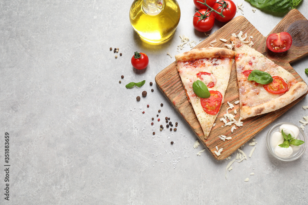 Slices of delicious pizza Margherita on light grey table, flat lay. Space for text Slices of delicious pizza Margherita on light grey table, flat lay. Space for text